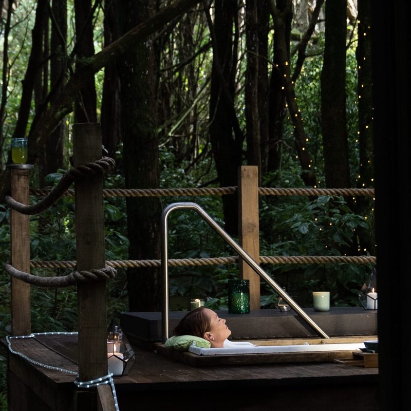 women in an outdoor bath in invercargill with trees and native birds